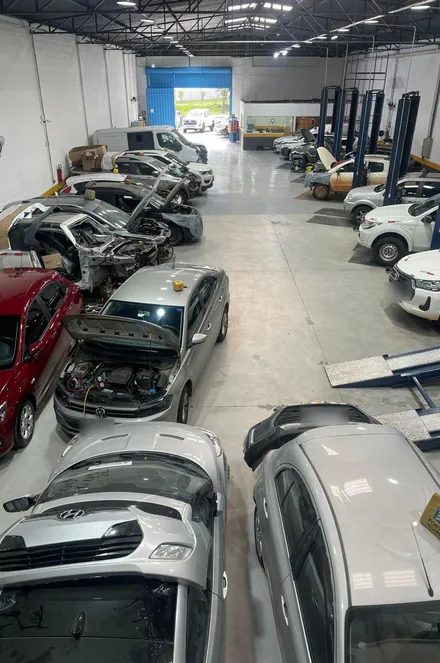 Área interna da oficina com os elevadores e carros em serviço