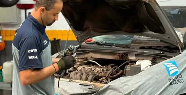 Mecânico da Destacar trabalhando no motor de um carro